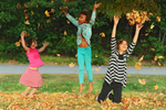 From left, Layla Vickers, 5, Amalia Thompson, 5, and Olivia Thompson, 8, all of West Barnstable blissfully toss leaves in the air in front of West Barnstable Elementary School on the second day of autumn.  