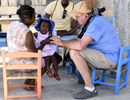 Dr. John Harrington of Gardner performs an exam on a young girl at the Adventist Church in Ducis, Haiti on Wednesday, November 2, 2016. 