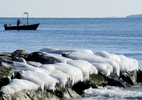 FALMOUTH -- 010914 -- A fisherman hauls up his catch near an ice-coated jetty off Surf Drive on Vineyard Sound.   Christine Hochkeppel/Cape Cod Times