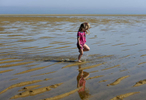 Kate Bassett, 5, of Brewster gets her feet wet at Point of Rocks Beach on Sunday. 