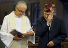 Rev. Mark Anschutz reads while Carroll {quote}Pete{quote} Gouger, 92, of South Yarmouth, who is an Air Force veteran of World War II and was a POW, wipes away a tear at the beginning of the Veterans Day Service of Remembrance at St. Mary's Episcopal Church.  