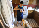 WEST YARMOUTH -- 071911 -- Back at home, Nickolas Qvarnstrom digs out a frosty pup treat to give to Keno after a walk in the hot weather.