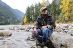 Scott Schuyler, policy representative for the Upper Skagit Tribe, sits on a rock on the bank of the Skagit River near the Diablo Dam on Thursday, November 9, 2023. The area is near a historic village site named after the bears. The tribe is one of the lead advocates for grizzly reintroduction in the North Cascades.  225376