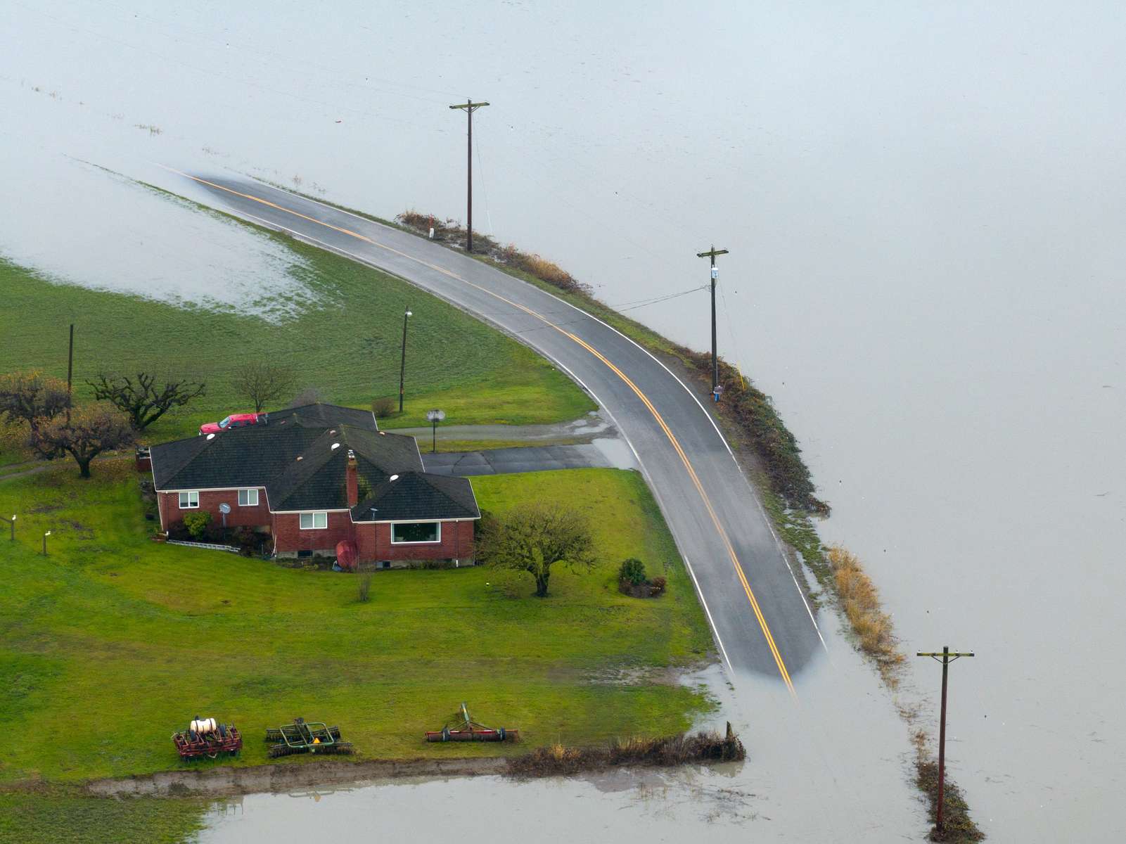 Closed roads and flooded farmlands by the Stillaguamish River on Norman Rd in Snohomish County on Wednesday, December 6, 2023. The Stillaguamish River set a preliminary record at 21.34 feet — the highest the river has ever risen — with major flooding.