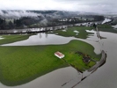 Closed roads and flooded farmlands by the Stillaguamish River (seen at the top) on Norman Rd in Snohomish County on Wednesday, December 6, 2023. The Stillaguamish set a preliminary record at 21.34 feet — the highest the river has ever risen — with major flooding