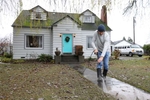 Kevin Buhr power washes silt away from his front walk in Silvana on Wednesday, December 6, 2023. He has lived here for 20 years and says he knew what he was getting into when he moved here. The Stillaguamish River set a preliminary record at 21.34 feet — the highest the river has ever risen — with major flooding in Silvana