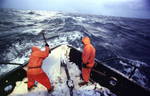 Heaving sledgehammers, two crew members begin a frigid January morning in 1995 by smashing a coat of frozen sea spray from the bow of the Polar Lady during opilio crab season in the Bering Sea. An iced-over boat can become dangerously top-heavy in rough seas and roll over. After four or so hours of sleep deckhands rise, beat ice off the boat with baseball bats and sledgehammers, and begin fishing. Crab fishing in the Bering Sea is considered to be one of the most dangerous jobs in the world. This fishery is managed by the Alaska Department of Fish and Game and is a sustainable fishery. The Discovery Channel produced a TV series called {quote}The Deadliest Catch{quote} which popularized this fishery. Today this fishery, largely based out of Dutch Harbor, AK has been consolidated resulting in a lot less boats fishing. © copyright Karen Ducey
