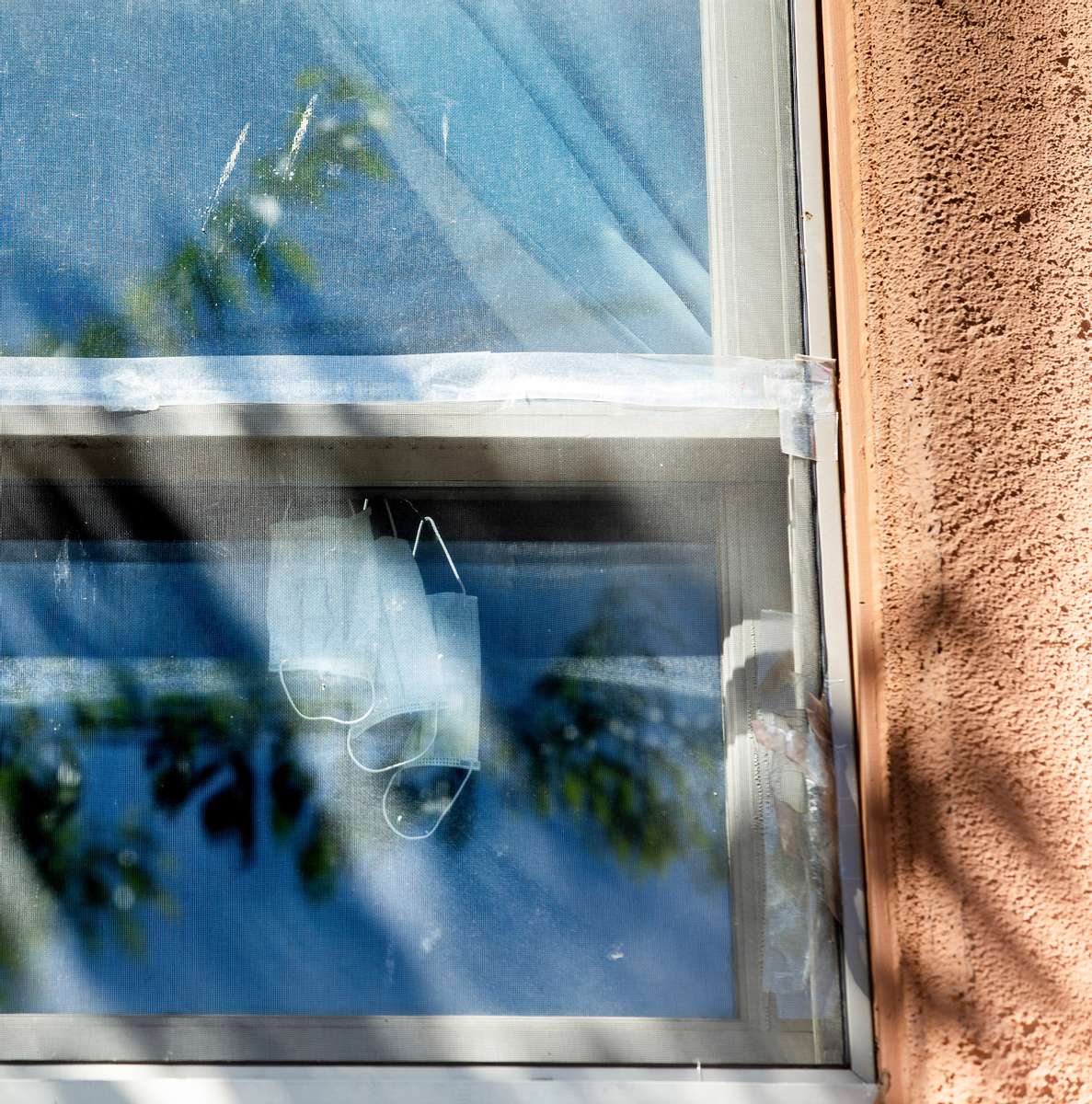 Surgical masks hang from a window in Seattle's Chinatown - International District on March 26, 2020. This project was produced in collaboration with the International Community Health Services (ICHS) documenting the effects of Covid-19  on the Chinatown-International District community. It was funded by Historic South Downtown, SPJ Western Washington Passion Project grant, and support from King County 4Culture. (photo by Karen Ducey)