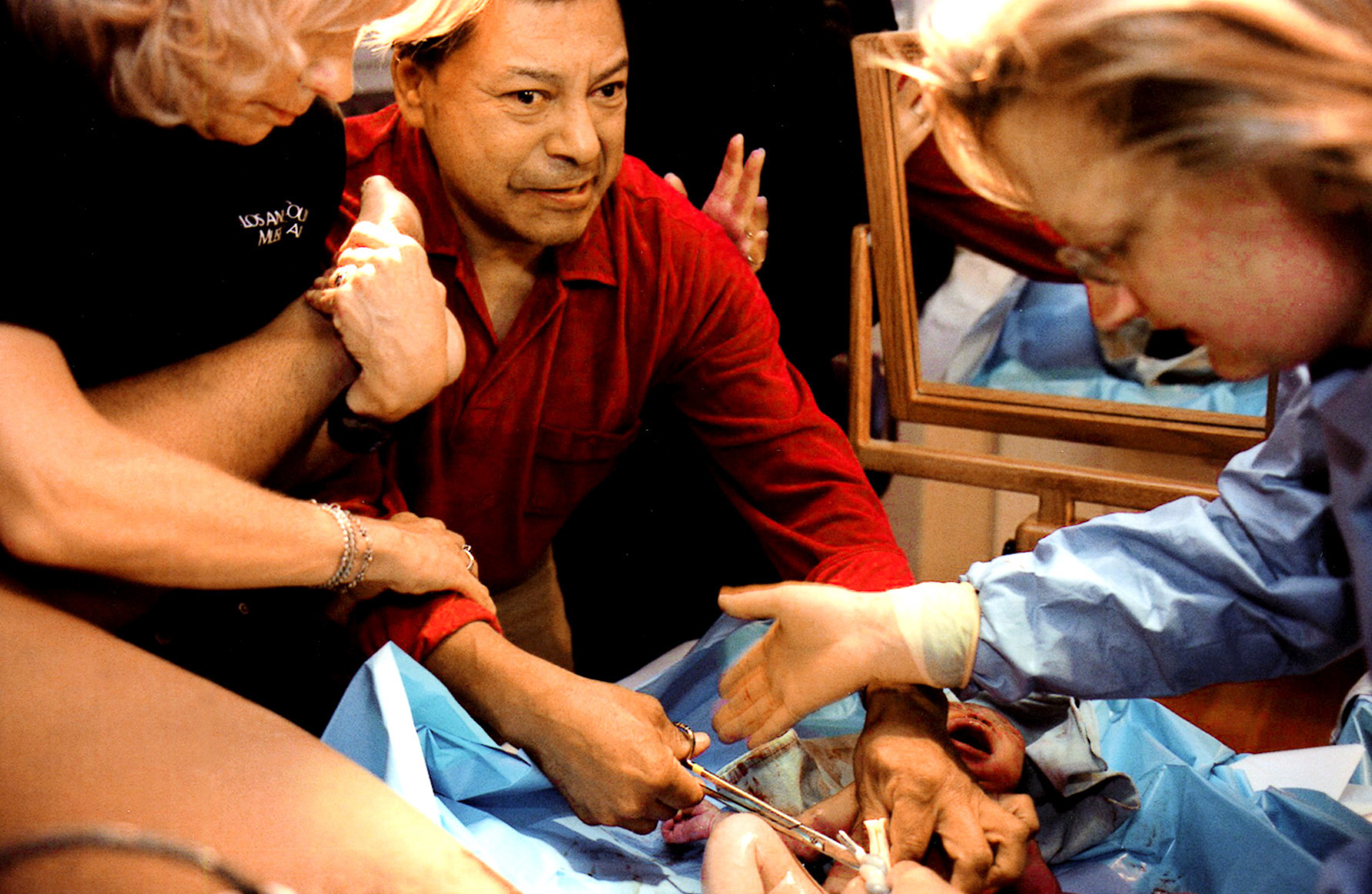 Medical staff and interpreters guide an excited Roy Rios in cutting the umbilical cord of his new daughter, Shanice Morgan-Rios. {quote}I hope my baby is not born deaf-blind with Usher's syndrome, like me,{quote} said Rios, who is deaf-blind and has three other siblings with the disease. Usher's is hereditary, there is no trreatment or cure. Rios already has a son, who was born without Usher's. Tests show that his daughter is able to hear. Doctors will test her later to determine whether she has any vision problems.