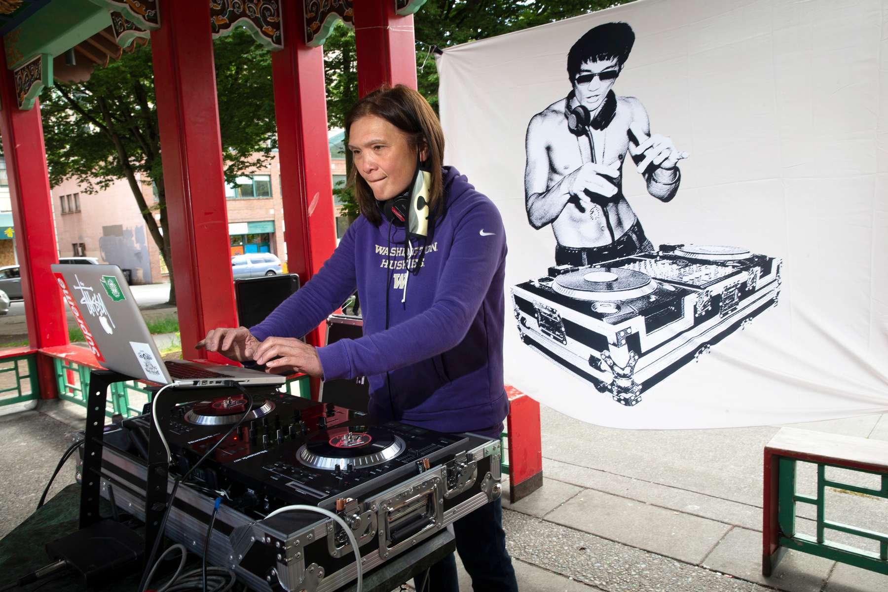 Sheila Locke from NastyMix Entertainment spins some Asian fusion tunes at Hing Hay Park during a community arts event in the Chinatown-International-District in Seattle Washington on June 14, 2020. Dozens of artists came together to paint murals in support of the Black Lives Matter movement on plywood at businesses that had been boarded up because of recent riots and the spread of coronavirus.