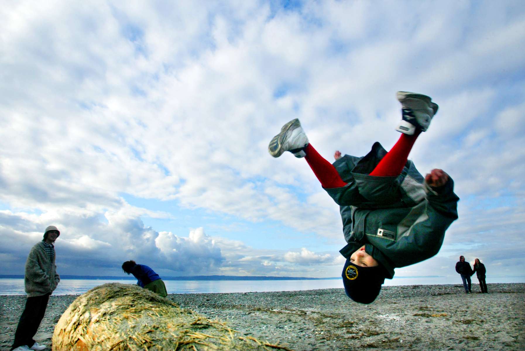 Connelly Brooks does a flip off a log at Carkeek Park in Seattle while his brother, Winfield (left), watches.   Winfield said they decided to spend the day at the park {quote}to enjoy the blue sky{quote}.