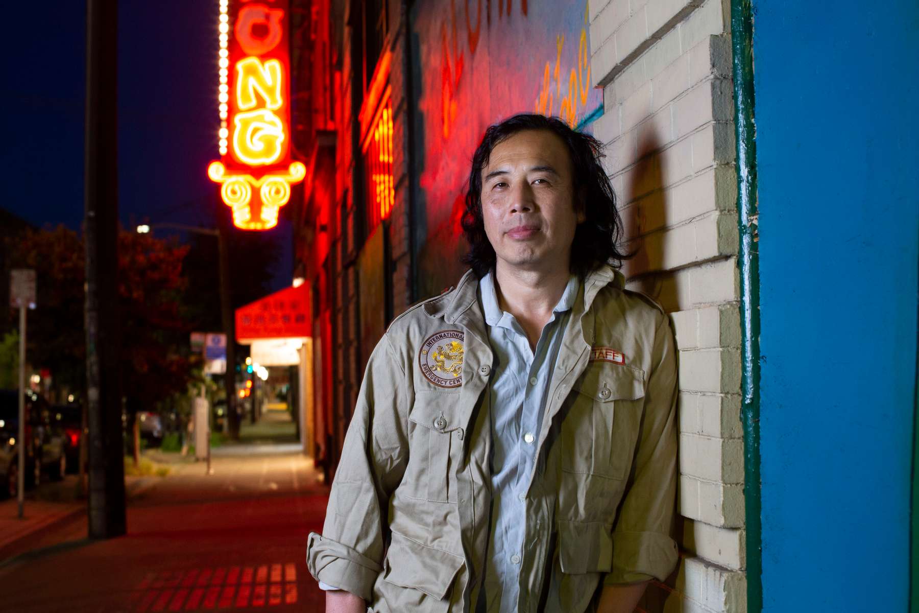Johnny Chan photographed in the Chinatown–International District in Seattle, Washington on July 15, 2020. Behind him is a photo of Donnie Chin on their bordered up storefront. Chan was one of “Donnie’s Kids” when he grew up in the neighborhood in the 80’s and spent a lot time and late nights working with Donnie to protect the neighborhood. Donnie Chin, director of the International District Emergency Center (IDEC) was murdered on July 23, 2015. The murderer was never found. (Photo by Karen Ducey) (Photo by Karen Ducey)