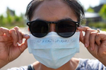 Rattana Chaokhote, Clinical Services supervisor at ICHS dons a mask that reads, {quote}This is not a health insurance plan,{quote} at a COVID-19 drive thru and walk-in testing site held for people in the Pacific Islander community in collaboration with International Community Health Services at Federal Way High School Federal Way, Washington on July 31, 2020. A recent report by the Washington State Department of Health (DOH) and Bellevue-based Institute for Disease Modeling (IDM) analyzing COVID-19 data highlight the pandemicís disproportionate and increasing impact on communities of color. Case rates over the pandemic for Hispanic people and Native Hawaiian or Other Pacific Islander people are nine times higher than those of White people. Hospitalization rates are seven times higher for Hispanics and ten times higher for Native Hawaiians or other Pacific Islanders than those of White people. ìWe know the COVID-19 pandemic has intensified the health inequities historically marginalized and oppressed communities already experience,î said Dr. Kathy Lofy, state health officer at DOH. ìThese data are deeply concerning and underline the critical need to address the COVID-19 impacts weíre currently seeing by prioritizing outreach, testing, education and related materials for disproportionately impacted communities in ways that are culturally and linguistically appropriate and accessible.