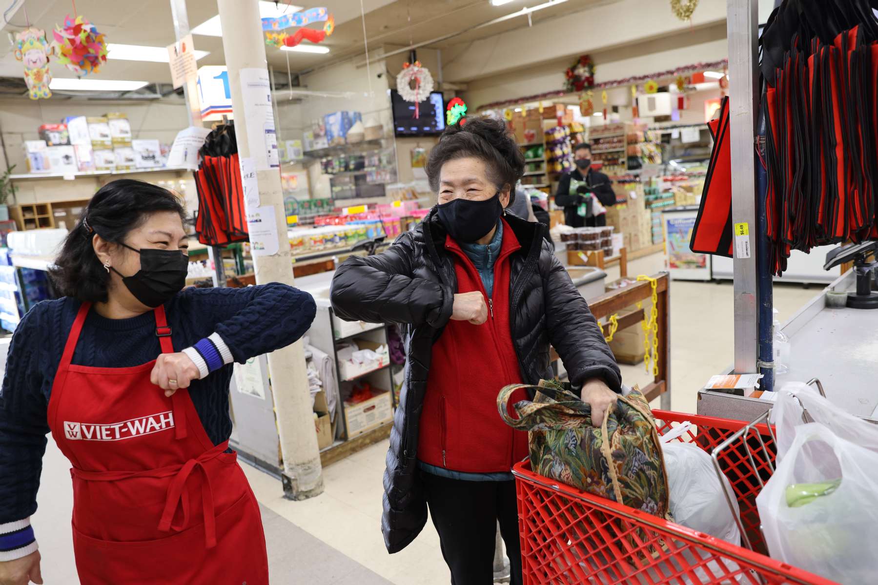 June Huynh (left) assistant manager, bumps elbows with Judy Lew as they greet each other at Viet-Wah, an Asian grocery store located in Seattle’s Little Saigon neighborhood, on February 24, 2021 in Seattle, Washington. Bumping elbows instead of shaking hands or hugging, became the proper way to greet someone to help curb the spread of Covid-19. (Photo by Karen Ducey)