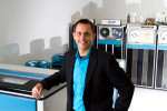 Senior Vice President and Chief Information Officer of Seattle Children's Hospital, Wes Wright, is photographed next to a Sigma 9 Mainframe printer at the Living Computer Museum in Seattle, Washington.  The Sigma 9 tape drives are in the background. (© copyright Karen Ducey)