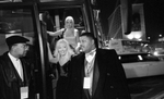 Police officer detective corporal Michael Jackson (right) stands guard as Miss California, Jennifer Jean, exits the beauties' bus outside the Genesis Convention Center on the final night of the Miss USA beauty pageant. © Karen Ducey 2001