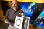 Roger Myers, Executive Director of advanced in-space programs at Aerojet, holds models of a Cygnus MR-107, a chemical thruster (left) and a 12kz XR-12 ion engine thruster for a future Mars mission (right) at the company headquarters in Redmond, WA. Aerojet is the oldest and most established of the local companies working in outer space. The Redmond company makes small rocket motors, most of them used to position satellites in outer space, or to guide long-distance exploration missions. (© copyright Karen Ducey)