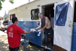 Shanton Alcaraz from the Salvation Army Northwest Division gives bottled water to Eddy Norby who lives in an RV and invites him to their nearby cooling center for food and beverages during a heat wave in Seattle, Washington, U.S., June 27, 2021. REUTERS/Karen Ducey