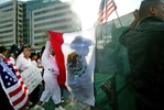 A man who didn't want to give his name, marches in front of a Mexican flag with 15,000 others in Seattle during a rally for immigration rights on April 10, 2006.  Asking for amnesty, equal rights, open borders, recognition and respect they demonstrated in solidarity with hundreds of thousands across America demanding immigration reform. Marchers head down King Street in Seattle during a rally for immigration rights on April 10, 2006. (PII photo/Karen Ducey)