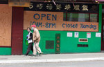 A couple walks past boarded up businesses in the Chinatown-International District in Seattle, WA on June 2, 2020. Businesses boarded up after a night of rioting swept up Jackson Street on May 29, 2020 and across the city the past couple of days. Protests around the country became violent after the killing of George Floyd, a black man in Minneapolis, who died while in the custody of white police officers, one of whom held him down with his knee. (Photo by Karen Ducey)