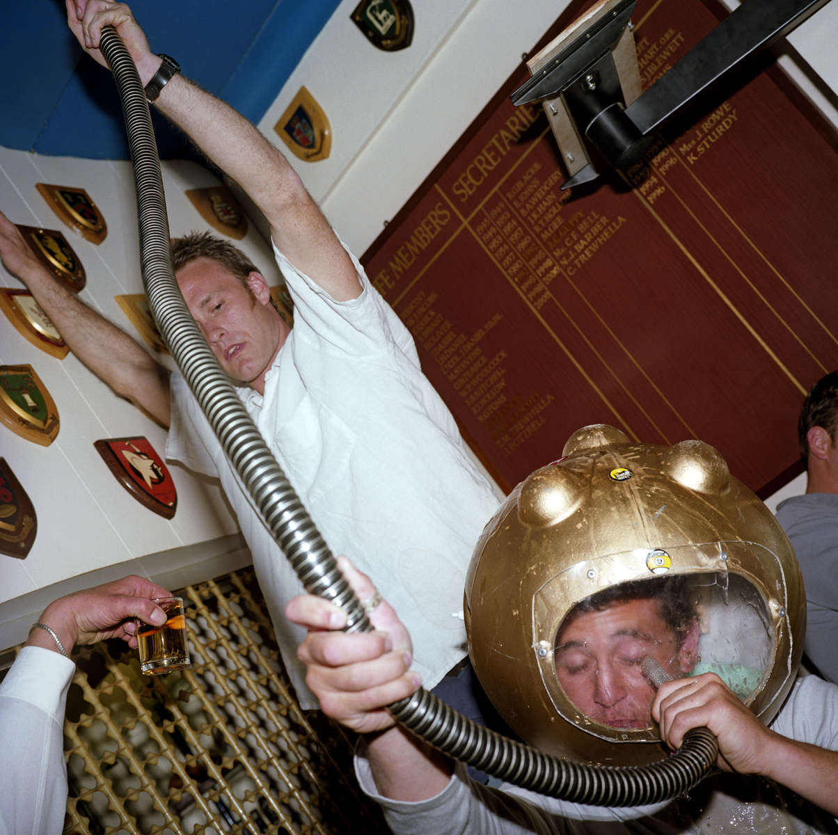 A male guest at a wedding reception in a St Ives rugby club drinks a pint of Guinness and a large whisky through the tube of a deep-sea diver themed beer bong. May 2001