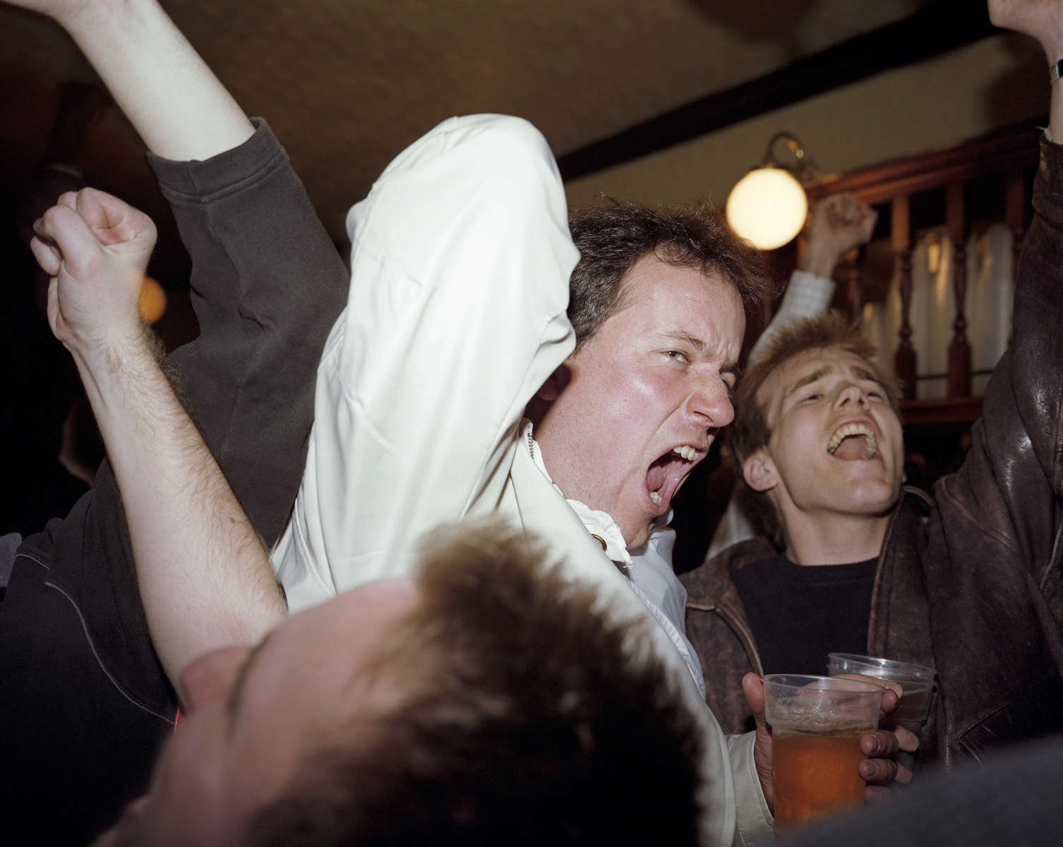 In a south London pub, England football fans celebrate a goal during a World Cup qualifier against Sweden. March 2001