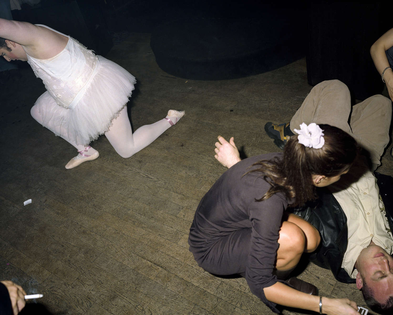 A male entertainer dressed as a ballerina performs in a central London nightclub next to a man lying on the floor. May 2000