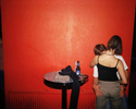 A young couple kiss passionately by a red wall in a Newquay nightclub. July 2001