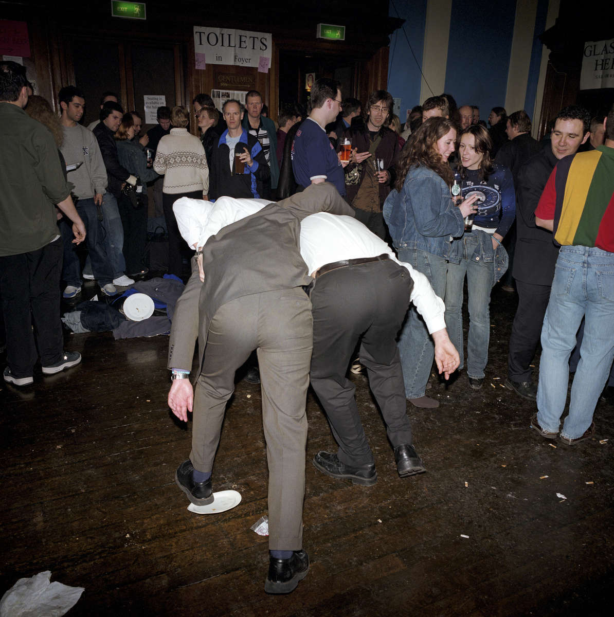 Two male visitors to a beer festival organised by CAMRA in north London make their way towards the toilet. March 2001