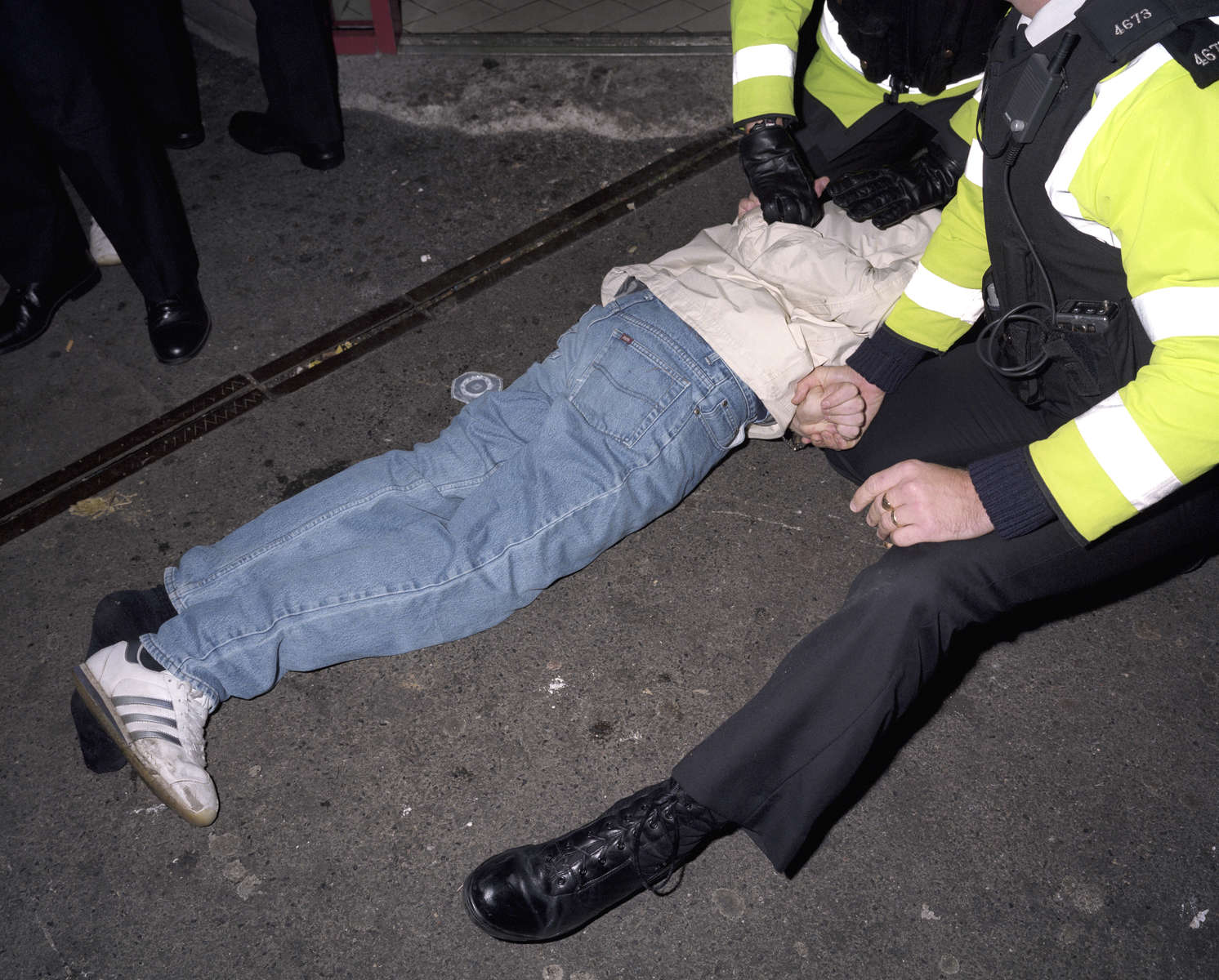 A young man is restrained by police officers after they intervene to break up a fight outside a kebab shop on Union Street in Plymouth. November 2001