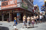 15:14 A group of British men, most of who are not wearing shirts, head in to the part of San Antonio town, Ibiza, known as the West End. The fine for not wearing a top in town centres and public areas is up to €750.