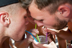 15:56 Three men drink through coloured straws from one drink during an afternoon swimming pool party at Club Aqua in Ayia Napa, Cyprus. The party is hosted at the club each week during the season for tourists and seasonal British workers.