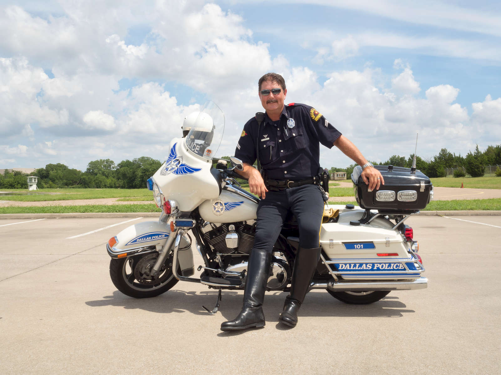 Motorcycle unit police officer Mike J Mitchell volunteers at the basic day training of the Dallas Junior Police Academy. His Harley Davidson bike weighs around 850lb and can do 110 miles an hour; he has been in the police for 26 years and hopes to retire in two.Dallas is a major city in Texas and is the largest urban center of the fourth most populous metropolitan area in the United States. The city ranks ninth in the U.S. and third in Texas after Houston and San Antonio. The city's prominence arose from its historical importance as a center for the oil and cotton industries, and its position along numerous railroad lines.For two weeks in the summer of 2015, photographer Peter Dench visited Dallas to document the metroplex in his epic reportage, DENCH DOES DALLAS.Photographed using an Olympus E-M5 Mark II©Peter Dench/Getty Images Reportage