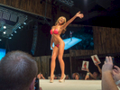 A finalist on stage at the Twin Peaks 2015 National Bikini Contest where around 68 girls from the USA competed for the crown for Miss Twin Peaks 2015, hosted at Gas Monkey Live, Dallas on the 24th June.Twin Peaks is a chain of sports bars and restaurants (colloquially referred to as breastaurants) based in Dallas, Texas. The chain is known for having its waitresses dress in revealing uniforms that consist of cleavage- and midriff-revealing red plaid (or sometimes black bikini) tops, as well as khaki short shorts. At other times, waitresses wear revealing seasonal or themed outfits. Restaurants are decorated in the theme of a wilderness lodge and serve a mix of American, Southwest and Southern cuisines as well as alcohol. The chain's slogan is {quote}Eats. Drinks. Scenic Views.{quote}Dallas is a major city in Texas and is the largest urban center of the fourth most populous metropolitan area in the United States. The city ranks ninth in the U.S. and third in Texas after Houston and San Antonio. The city's prominence arose from its historical importance as a center for the oil and cotton industries, and its position along numerous railroad lines.For two weeks in the summer of 2015, photographer Peter Dench visited Dallas to document the metroplex in his epic reportage, DENCH DOES DALLAS.Photographed using an Olympus E-M5 Mark II©Peter Dench/Getty Images Reportage