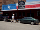A man walks past the Armadillo bar on West Exchange Avenue, Stockyards, Fort Worth.The Fort Worth Stockyards is a historic district that is located in Fort Worth, Texas, north of the central business district. The 98-acre (40 ha) district was listed on the National Register of Historic Places as Fort Worth Stockyards Historic District in 1976.They are a former livestock market which operated under various owners from 1866.Dallas is a major city in Texas and is the largest urban center of the fourth most populous metropolitan area in the United States. The city ranks ninth in the U.S. and third in Texas after Houston and San Antonio. The city's prominence arose from its historical importance as a center for the oil and cotton industries, and its position along numerous railroad lines.For two weeks in the summer of 2015, photographer Peter Dench visited Dallas to document the metroplex in his epic reportage, DENCH DOES DALLAS.Photographed using an Olympus E-M5 Mark II©Peter Dench/Getty Images Reportage
