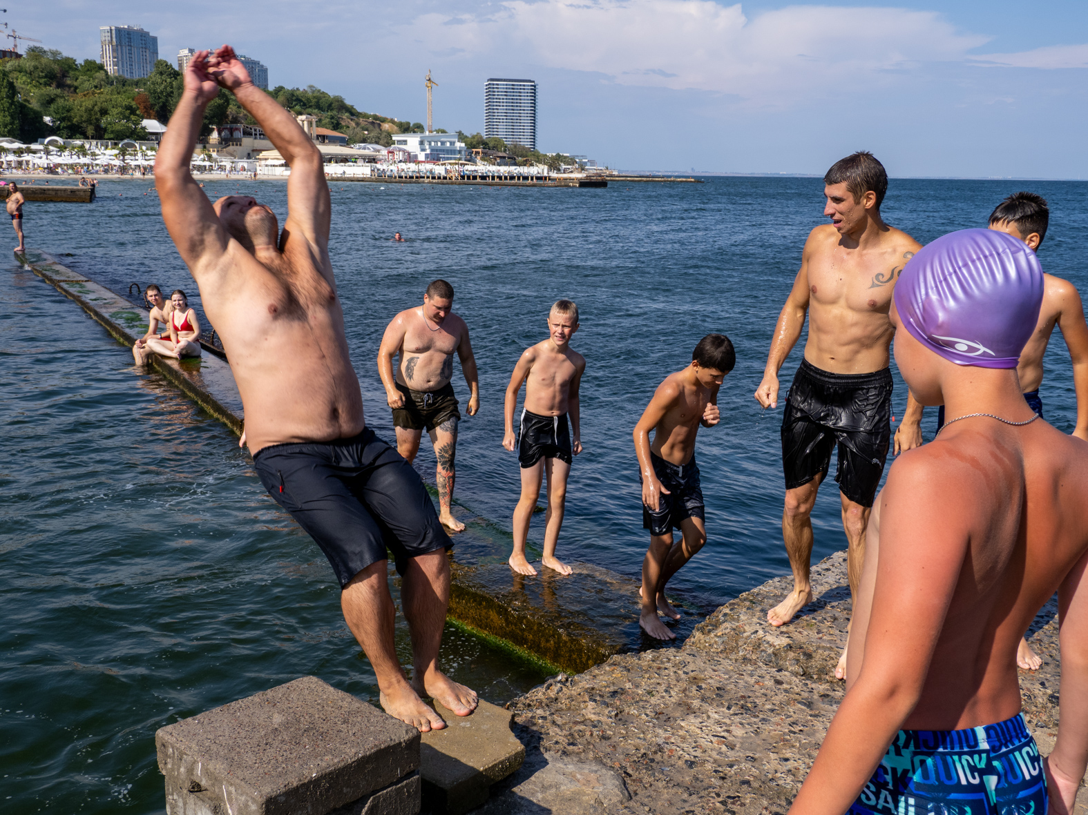 ODESSA, UKRAINE - AUGUST 26:  Visitors to the  beach on August 26, 2023 in Odessa, Ukraine. Several beaches in Ukraine's Black Sea city port of Odessa were officially reopened for swimming for the first time since the start of the Russian invasion, bathing remained banned during air raid alerts, an Anti-mine net was placed in between two piers to prevent swimmers encountering shallow-water mines many of which were dislodged by flood waters from the destruction of Kakhovka dam under control of the Russian military. The opening of the beaches has been a welcome respite from the tensions of war. (Photo by Peter Dench/Getty Images)