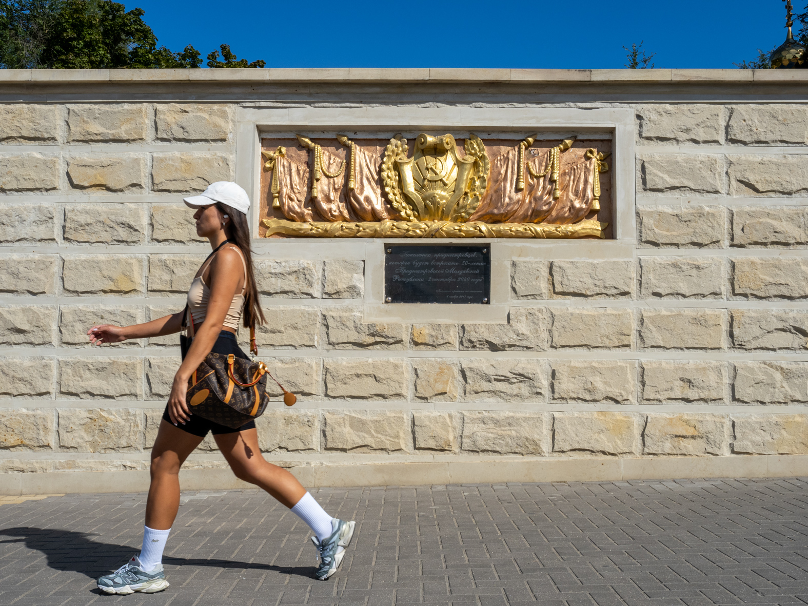 TIRASPOL, TRANSNISTRIA / MOLDOVA - SEPTEMBER 2: A woman walks past a hammer and sickle, part of a memorial on 25 October Street on September 2, 2023 in Tiraspol, Moldova (Pridnestrovian Moldavian Republic). Tiraspol is the capital of Transnistria situated on the eastern bank of the Dniester River. Republic Day is the main state holiday. Transnistria broke away from Moldova in 1990 and is unrecognised by the international community as an independent state. The de-facto administration of Transnistria is supported economically, diplomatically, and militarily by Russia, which is believed to have 1,500 soldiers stationed there. (Photo by Peter Dench/Getty Images)