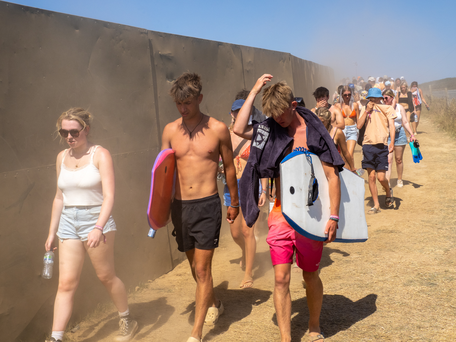 NEWQUAY, ENGLAND - AUGUST, 2022: Dust kicked up by viditors to Watergate Bay and Boardmasters Festival. During a heatwave in England, thousands of visitors headed to the town of Newquay, Cornwall for the surfing, beaches and Boardmasters Festival. Resources during the summer are stretched and some local residents are being pushed out of the area by tourists and due to an influx of holiday homes.
