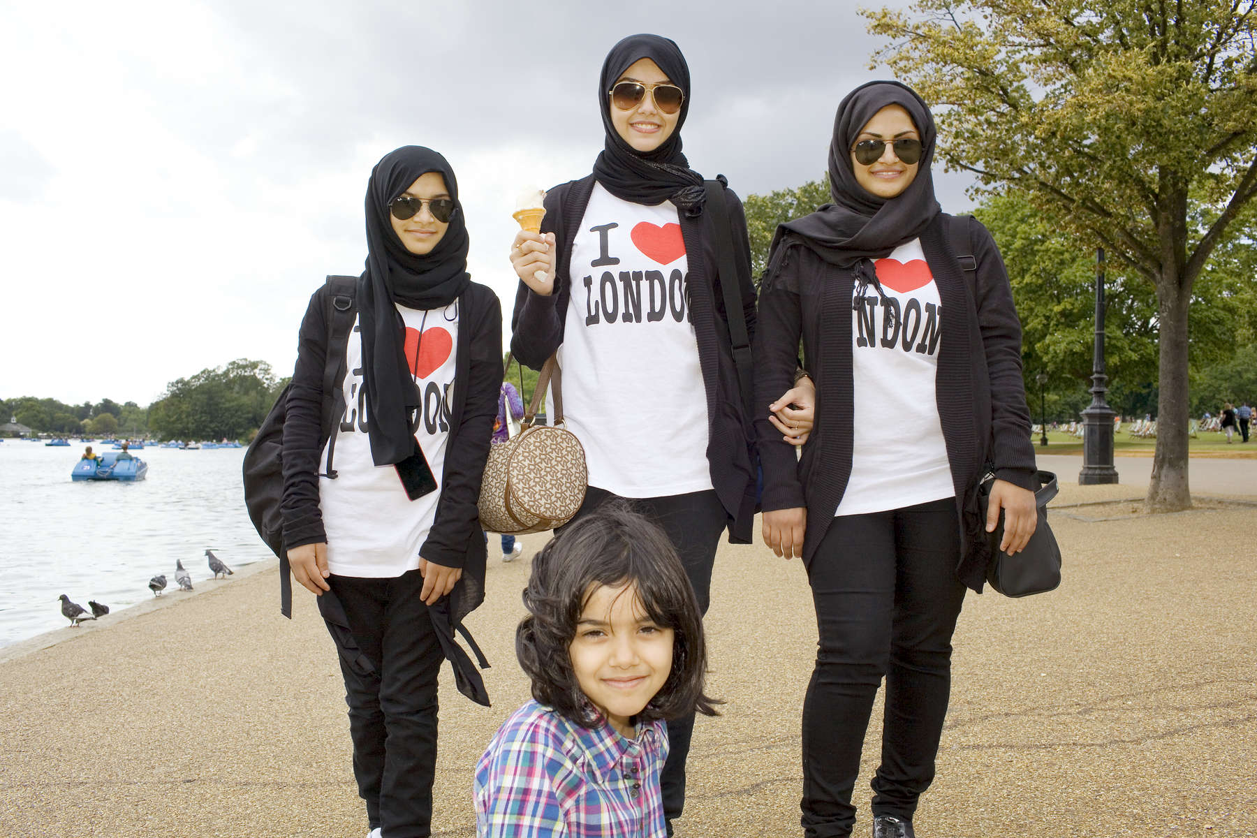 16-year-old Salma Mohammed, centre, is one Saudi Arabian who likes to visit the Serpentine lake in Hyde Park.Arabs have been visiting London for centuries and around 300,000 Arabs have chosen to make the capital their home and a further half a million throughout the UK. The number swells significantly from visitors during the summer. Saudi Arabians spend the most on property in London choosing Belgravia, Kenington, Knightsbridge and Holland Park. Arab culture continues to increase in visibility throughout the capital as integration into this most transient of city's continues.©Peter Dench/Reportage by Getty Images