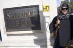 An Arab woman wearing sunglasses passes by the Selfridge & Co store located on London's busy Oxford Street, one of the busiest in Europe.Arabs have been visiting London for centuries and around 300,000 Arabs have chosen to make the capital their home and a further half a million throughout the UK. The number swells significantly from visitors during the summer. Saudi Arabians spend the most on property in London choosing Belgravia, Kenington, Knightsbridge and Holland Park. Arab culture continues to increase in visibility throughout the capital as integration into this most transient of city's continues.©Peter Dench/Reportage by Getty Images