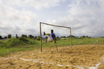 An amputee exercises on a pitch modified for amputee matches. The goal is half the size of the orthodox version.In disaster areas, war zones and urban wastelands, football keeps humanity alive. It brings nations together and promotes unity. It encourages equality and generates pride and self-belief. It has the power to heal and to help, to motivate, to give freedom to dreams and empower a generation. There are millions of people playing the game or helping it to flourish who find that football brings a positive dimension to their lives.Away from the billionaire owned clubs with it's multi-million dollar players, Football's Hidden Story is a series of emotive human interest photographs showing the positive impact football has had at grassroot level on individuals and communities all around the world. 