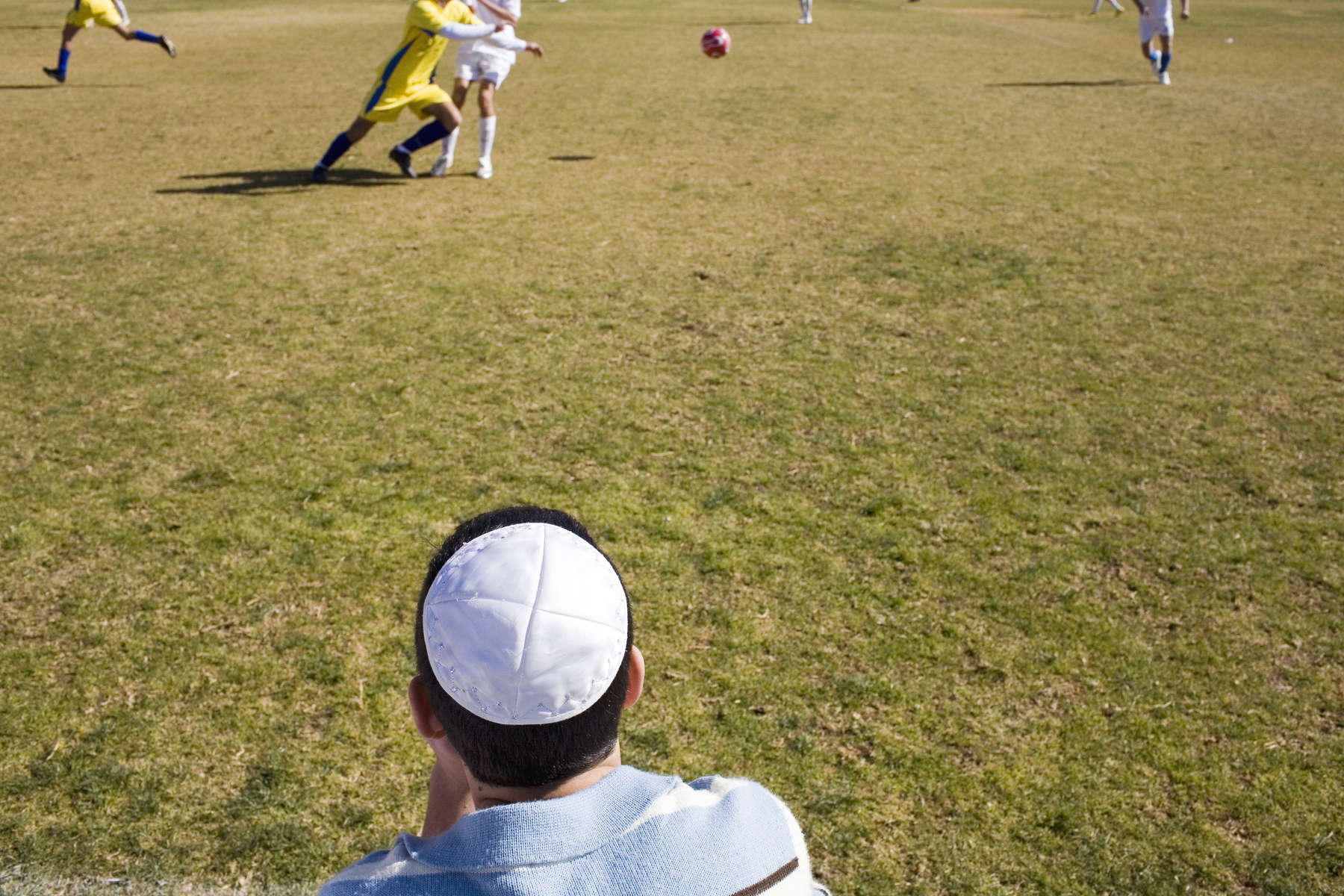 A Jewish fan watches a football match between Katamon Abu Ghosh Mevaseret FC, a mixture of Arabs and Jewsish players, and a team of Druze from the occupied Golan Heights, the first ever Syrian-born football team to play in Israel.In disaster areas, war zones and urban wastelands, football keeps humanity alive. It brings nations together and promotes unity. It encourages equality and generates pride and self-belief. It has the power to heal and to help, to motivate, to give freedom to dreams and empower a generation. There are millions of people playing the game or helping it to flourish who find that football brings a positive dimension to their lives.Away from the billionaire owned clubs with it's multi-million dollar players, Football's Hidden Story is a series of emotive human interest photographs showing the positive impact football has had at grassroot level on individuals and communities all around the world. 