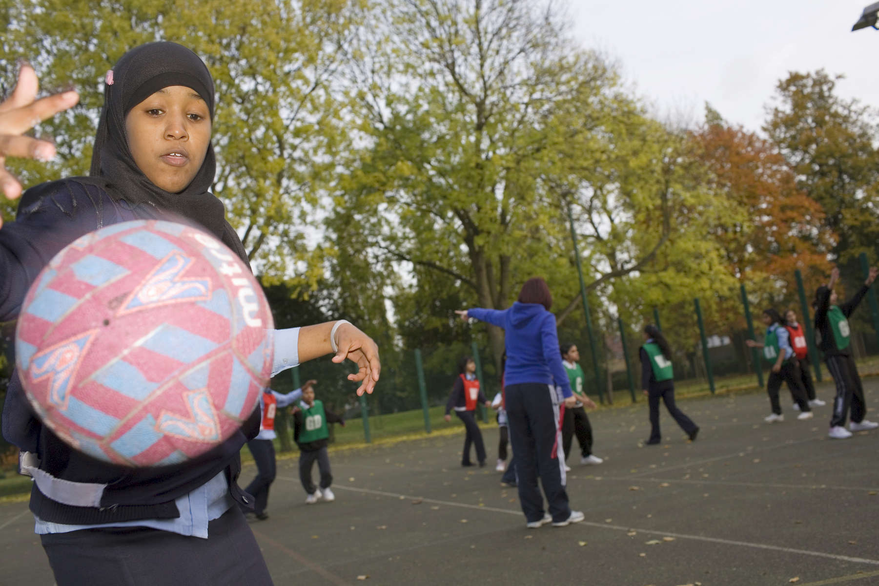 The Tuesday after school netball club in action on one of the outside courts at Villiers High School. Staff at Villiers urge parents to actively encourage their children to attend at least one extra curricular club. Netball is particularly popular with female pupils from South Asia.Villiers High School is in the town of Southall. It has a very wide ethnic diversity. 45 different 1st spoken languages are listed among the 1208 pupils. 25 ethnic groups are represented with Indian, Pakistani and Black-Somali the three highest.Southall is a suburban district of West London, England. The town has one of the largest concentrations of South Asian people outside of the Indian sub-continent. Over 55% os Southall's population of 70,000 is Indian/Pakistani, with less than 10% being White British.