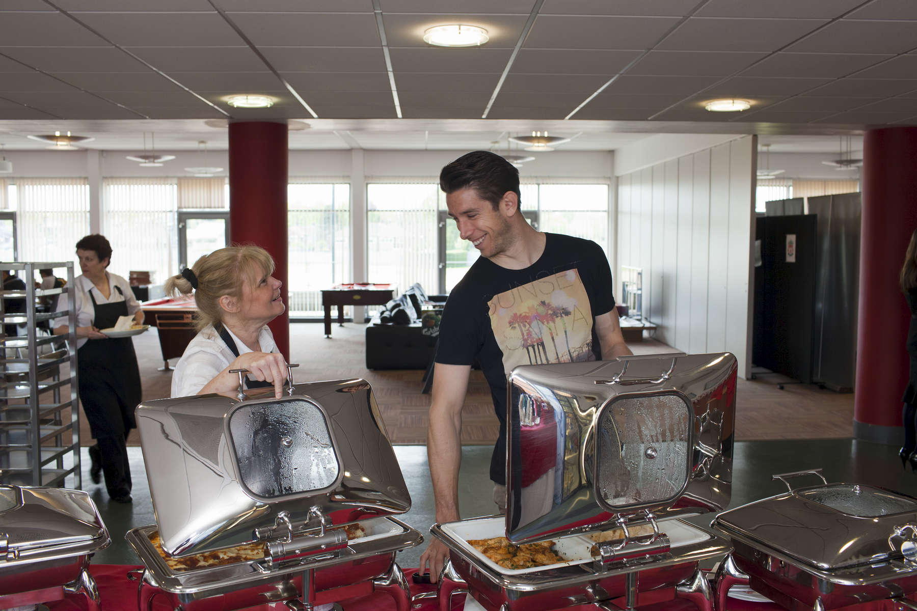 Liverpool FC player Brad Jones chats with canteen staff on training day at Melwood.Melwood is the Liverpool FC training ground, located in the West Derby area of Liverpool. It is seperate from the Liverpool Academy, which is based in Kirkby.Melwood was redeveloped in the early 2000′s with large input from then-manager Gerard Houllier and now features some of the best facilities in Europe. It has been the club’s training ground since the fifties and was previously transformed into a top class facility by Bill Shankly.Facilities include sythetic pitches, rehabilitation rooms, press and meeting rooms, gymnasium, swimming pool, restaurant and recreational facilities.
