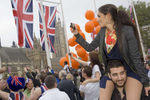 Dalia Yousif sits on the shoulders of her partner Panos to take photographs from Parliament Square of guests arriving at Westminster Abbey for the Royal Wedding.