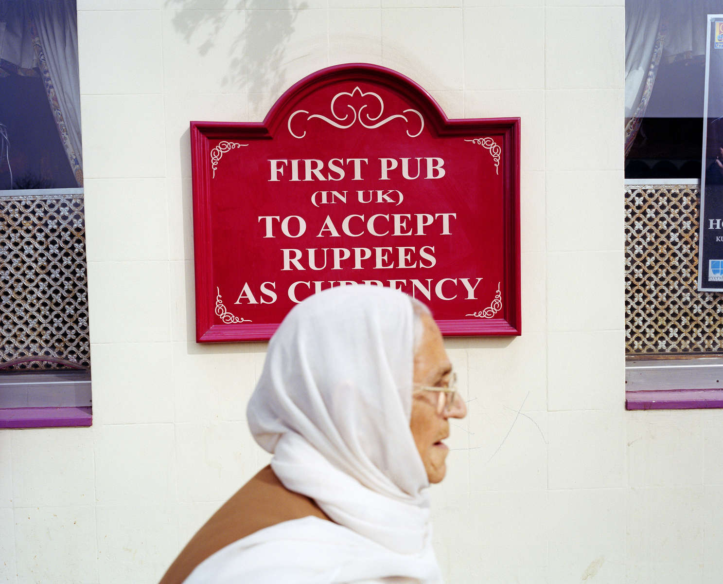 A woman walks past the Glassy Junction pub, the first in the UK to accept the indian rupee as currency.