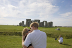 A couple share a passionate kiss in fornt of Stonehenge. Stonehenge is a prehistoric monument located in the English county of Wiltshire. One of the most famous prehistoric sites in the world, Stonehenge is composed of earthworks surrounding a circular setting of large standing stones. Archaeologists believe that the iconic stone monument was erected around 2500 BC.