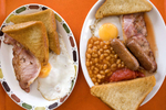 Two traditional English Breakfasts served on a tray in a cafe in Blackpool. At the heart of the breakfast is bacon and eggs and usually accompanied by a choice of fried bread, toast, tomatos, beans and mushrooms.