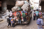 Schoolchildren hitch a ride on the back of a garbage collection truck driving through the central street of Moqqatam.Moqqatam is a suburb on the edge of Cairo and home to a people known as the Zabaleen, said to be the world’s greatest waste recyclers. The Zabaleen, which means plainly enough, “the garbage collectors”, pick up around 4,000 tons of Cairo’s waste each day. American researchers have shown that the Zabaleen recycle 85% of this garbage into something useful: a higher rate than anywhere else on the planet. The men do two shifts leaving about 4am and again around 9am. The rubbish is taken back to Moqqatam for the women to sit in and sort through. The organic waste is fed to livestock (the Zabaleen are originally swine herders), the rest sorted for recycling. The future of the Zabaleen is uncertain: if the Cairo authorities get their way, this community of around 25,000 Coptic Christians living in a Muslim country will be gone, and with it, their unique lifestyle.