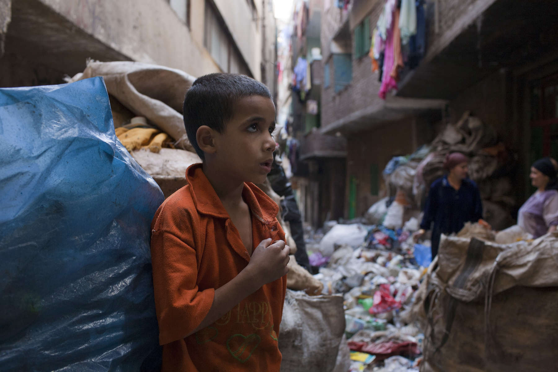 A young Zabaleen boy in a street strewn with garbage for recycling.Moqqatam is a suburb on the edge of Cairo and home to a people known as the Zabaleen, said to be the world’s greatest waste recyclers. The Zabaleen, which means plainly enough, “the garbage collectors”, pick up around 4,000 tons of Cairo’s waste each day. American researchers have shown that the Zabaleen recycle 85% of this garbage into something useful: a higher rate than anywhere else on the planet. The men do two shifts leaving about 4am and again around 9am. The rubbish is taken back to Moqqatam for the women to sit in and sort through. The organic waste is fed to livestock (the Zabaleen are originally swine herders), the rest sorted for recycling. The future of the Zabaleen is uncertain: if the Cairo authorities get their way, this community of around 25,000 Coptic Christians living in a Muslim country will be gone, and with it, their unique lifestyle.